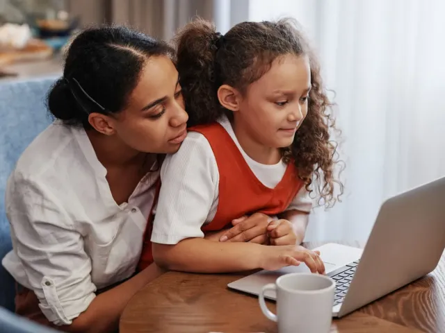 A mother and daughter choosing a program on a laptop