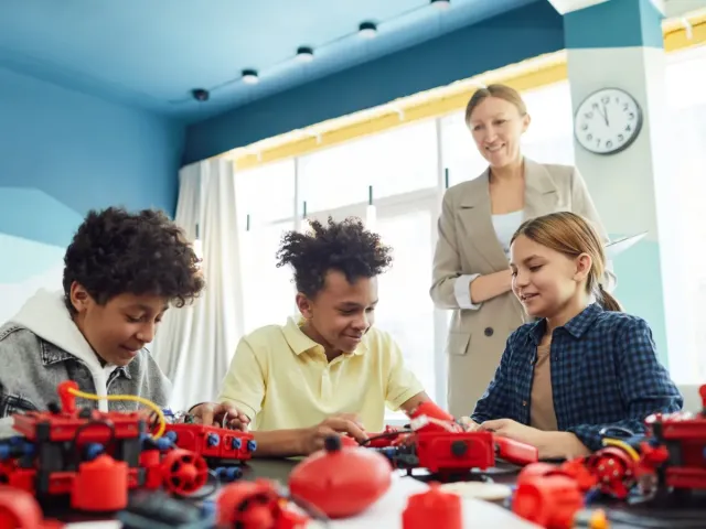 Kids building a robot together in class